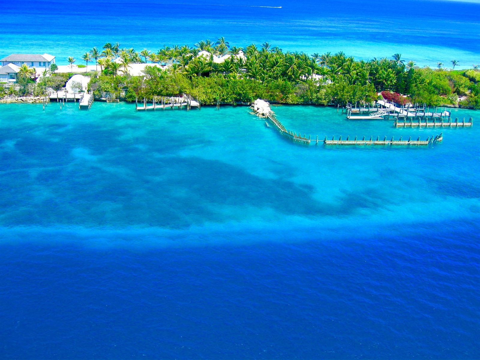 Aerial view of turquoise water and a green island shoreline near Nassau, Bahamas